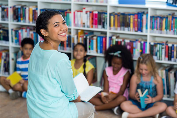 A teacher reading to a group of young students